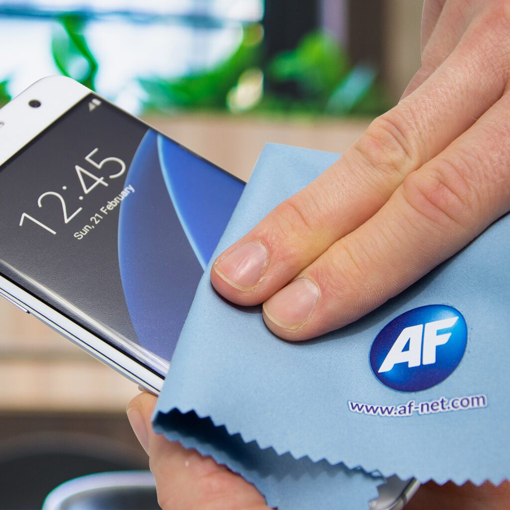 Hand cleaning phone screen with microfiber cloth.